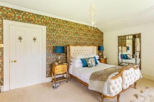 a bedroom with a bed and a mirror at Luxury Scottish Manor house + jacuzzi + bbq cabin + helipad in Maybole