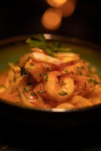 un tazón de comida con camarones y perejil. en Porto Marina Hotel, en Guatapé