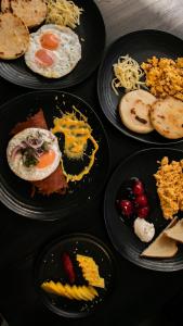 a table topped with plates of food with eggs and bread at Porto Marina Hotel in Guatapé