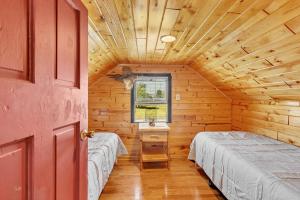 a bedroom with two beds in a log cabin at Eagles Nest Motel Unit 3BD in Escanaba