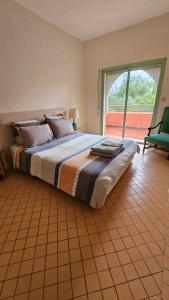 um quarto com uma cama grande e uma janela grande em Appartement Palmeraie Marrakech em Marrakech