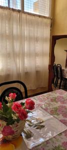 une table avec un bol de roses au-dessus dans l'établissement Kenny G, à Tinogasta