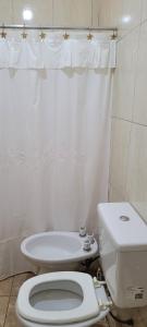 Baño blanco con aseo y lavamanos en Kenny G en Tinogasta