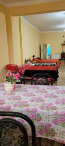 um quarto com três camas e mesas com flores em Kenny G em Tinogasta