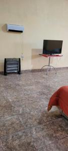 Cette chambre dispose d'une télévision, d'une table et d'une chaise. dans l'établissement Kenny G, à Tinogasta