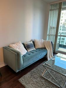 a living room with a couch and a glass table at Lakeview Condo in Downtown with Free Parking. in Toronto
