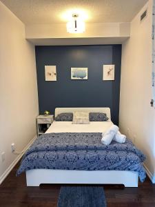 een slaapkamer met een bed met een blauwe muur bij Lakeview Condo in Downtown with Free Parking. in Toronto