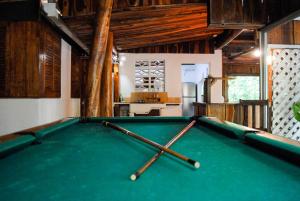 a pool table in a room with two pool sticks at Hacienda Sarah in Nosara