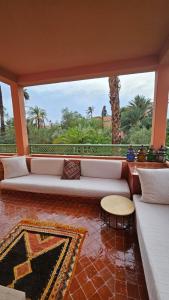 uma sala de estar com um sofá e uma grande janela em Appartement Palmeraie Marrakech em Marrakech