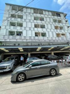 een zilveren auto geparkeerd voor een gebouw bij 辉煌 Icon 民宿 in Bangkok
