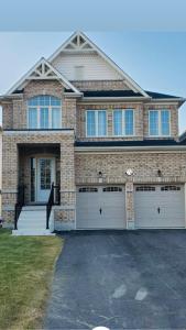 a large brick house with two garage doors at Brand new luxurious home, located in Lindsay. in Kawartha Lakes