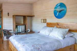 1 dormitorio con 1 cama y 1 mesa en Hostal Sirena en Pichilemu