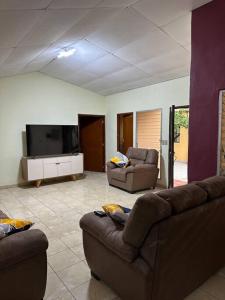 a living room with two couches and a flat screen tv at Casa de Campo en Salcoatitan in Salcoatitán