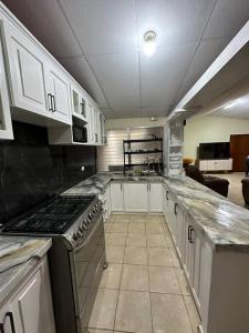 a kitchen with white cabinets and a stove top oven at Casa de Campo en Salcoatitan in Salcoatitán