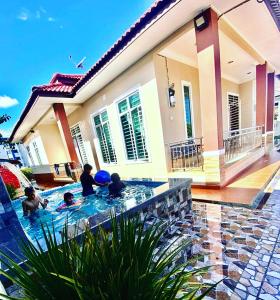 - un groupe de personnes dans une piscine dans une maison dans l'établissement Cassa Villa Guest House Pasir Mas, à Pasir Mas
