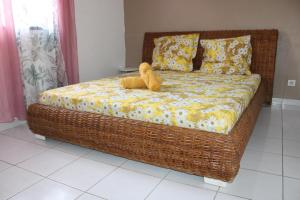 a wicker bed with a teddy bear sitting on it at Villa Rubis - proche aéroport in Matoury