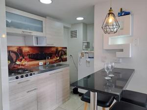 a kitchen with white cabinets and a black counter top at Apartamento moderno cerca del aeropuerto in Bogotá