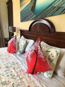 a bed with four pillows on top of it at Villas Segovia Hotel Boutique & Suites in Cozumel