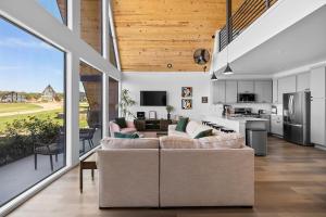 a living room with two couches and a kitchen at Gruene Lake Haus - Modern A-Frame with Fire Pit in New Braunfels