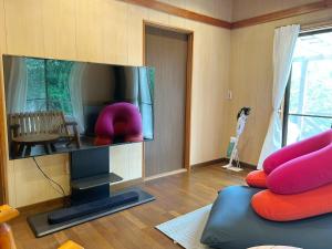 a living room with a large flat screen tv at フォレストハウス伊豆箱根 in Kannami