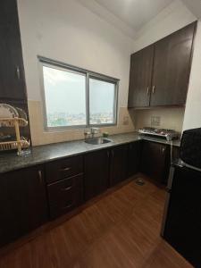 an empty kitchen with a sink and a window at Balcony View/Aesthetic One bedroom Apartment in Islamabad