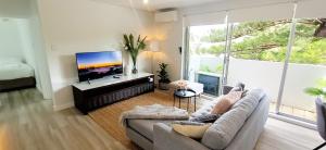 Il comprend un salon doté d'un canapé et d'une télévision à écran plat. dans l'établissement Moments to famous Bondi Beach, à Sydney