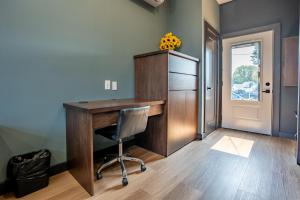 a home office with a wooden desk and a chair at Lux Hotel 