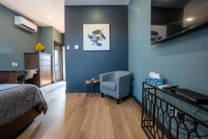 - une chambre avec des murs bleus, un lit et une chaise dans l'établissement Lux Hotel, 