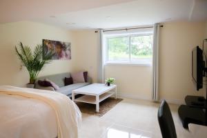 a bedroom with a bed and a couch and a window at Nature Oasis Mar Suite in Dundas