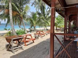 a group of picnic tables on the beach at Permai Chalet Tioman in Kampong Juara +35 photos
