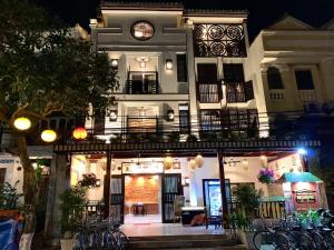 un edificio con un reloj encima por la noche en Hoi An Pho Library Hotel, en Hoi An