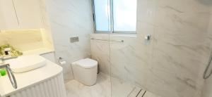 a white bathroom with a toilet and a sink at Moments to famous Bondi Beach in Sydney