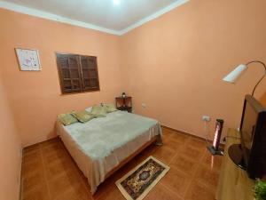 1 dormitorio con cama, ventana y TV en Barrio Residencial San Martín - La Chacarita en San Fernando del Valle de Catamarca
