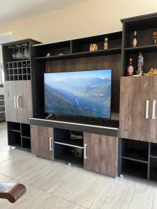 ein großes Entertainment-Center mit einem Flachbild-TV in der Unterkunft Casa 3 dormitorios. - Barrio Valle Cercano in Cordoba + 13 Fotos