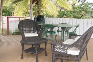 patio ze stołem i krzesłami na tarasie w obiekcie Vanylle Lodge w mieście Punaauia