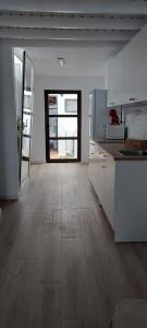 una cucina con mobili bianchi e pavimento in legno di Mi refugio en el mar a Playa Honda