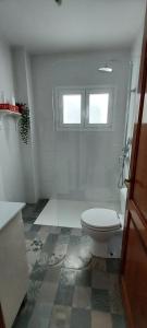 bagno bianco con servizi igienici e finestra di Mi refugio en el mar a Playa Honda
