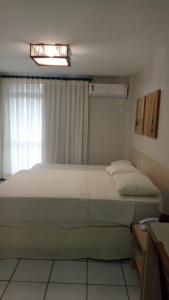 Cama grande en habitación con ventana en Gran Lençóis Flat Residence Apartamento Atins 109 en Barreirinhas