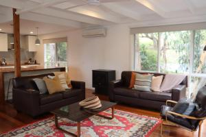 Whispering Gums - Ocean Views, Pet Friendly, EV UNIT 7kW for electric cars, Sleeps 7 في لورن: غرفة معيشة مع كنبتين وطاولة