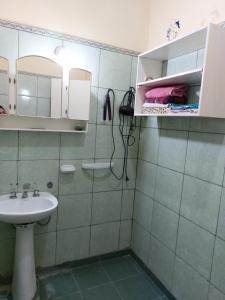 uma casa de banho com um lavatório e um chuveiro com um espelho. em Barrio Residencial San Martín - La Chacarita em San Fernando del Valle de Catamarca