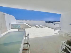 プンタ・カナにあるPh in Cana Rock Star With Golf View And Poolのテーブルと椅子と青い空のある白い部屋