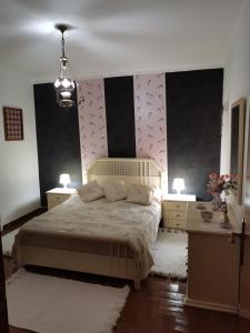 ein Schlafzimmer mit einem großen Bett und zwei Nachttischen in der Unterkunft Por A Mor in Figueiró dos Vinhos
