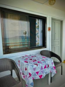 Playa Blanca Beach Resort في بويرتو غاليرا: طاولة وكرسيين في غرفة مع نافذة