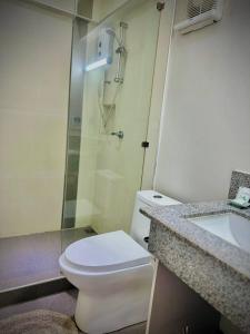 uma casa de banho com um WC, um chuveiro e um lavatório. em Playa Blanca Beach Resort em Puerto Galera