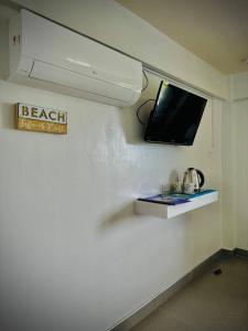 um quarto com uma televisão na parede em Playa Blanca Beach Resort em Puerto Galera