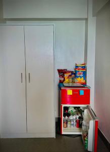 a small refrigerator with food in it next to a white cabinet at Playa Blanca Beach Resort in Puerto Galera