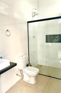 uma casa de banho com um WC e uma cabina de duche em vidro. em Recanto Algodão-Doce - Área de Lazer em São Carlos em São Carlos