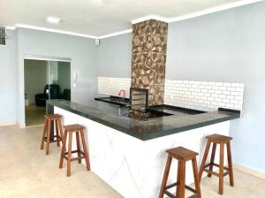 a kitchen with a counter and stools in a room at Recanto Algodão-Doce - Área de Lazer em São Carlos in São Carlos