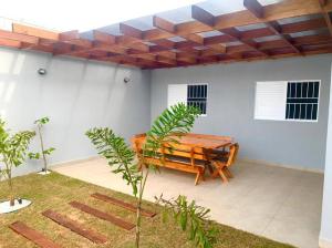 a patio with a wooden bench and a table at Recanto Algodão-Doce - Área de Lazer em São Carlos in São Carlos