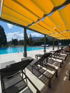 a group of lounge chairs and a swimming pool at Family House in Pine Mountain Club